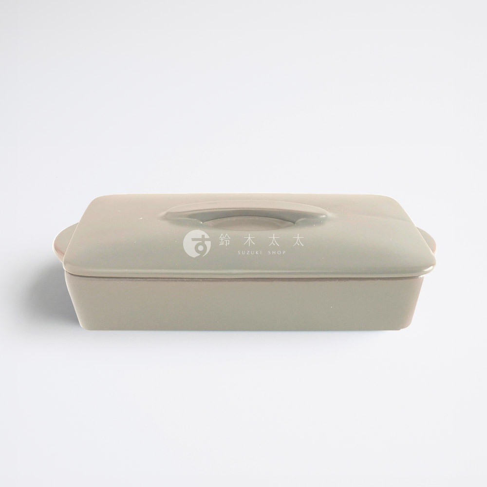 一個放置於純白背景的 SALIU 品牌耐熱陶製萬用長方形烤盤，外觀呈現溫潤的灰白色調。烤盤配有同材質的平整蓋子，蓋子中央設有橫向弧形提把，整體設計簡約現代，展現出職人手工製作的細緻質感。