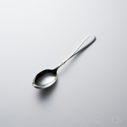 Flora系列不鏽鋼點心匙，銀色，帶有裝飾細節的握柄，置於淺灰色背景上。