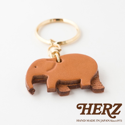 職人手作皮革大象造型鑰匙圈，由棕褐色皮革製成，搭配金色金屬鑰匙環，造型可愛，展現精緻工藝。