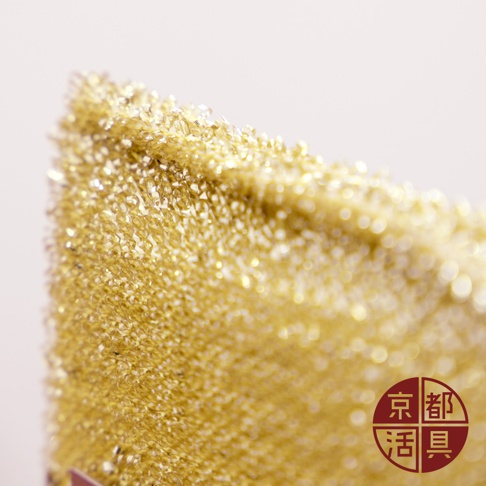 金黃色金屬絲製成的不沾鍋專用菜瓜布，表面呈現細緻的網狀結構，光澤感十足。