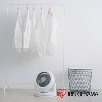 白色IRIS OHYAMA PCF-HM23 空氣循環扇，機身帶有控制按鈕，前置扇網為灰色螺旋紋，擺放在白色衣架和綠色網狀置物籃旁。