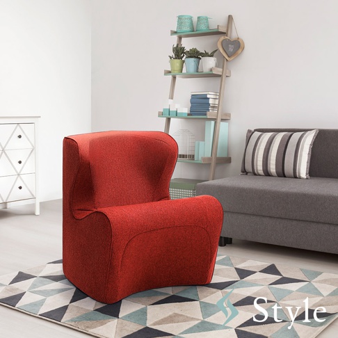 紅色布藝單人椅，椅背帶有弧度，扶手延伸至椅身，擺放在幾何圖案地毯上，背景為白色牆面、白色抽屜櫃、層架及灰色沙發。