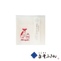 白色棉質方巾，繡有紅色卡通牛和一瓶牛奶圖案，下方有「Shirayuki」字樣。右側有日文標籤，材質為高級蚊帳生地。