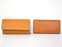 兩款淺棕色皮革長夾，左款為翻蓋式，右款為無翻蓋式，皆有車縫線裝飾。
