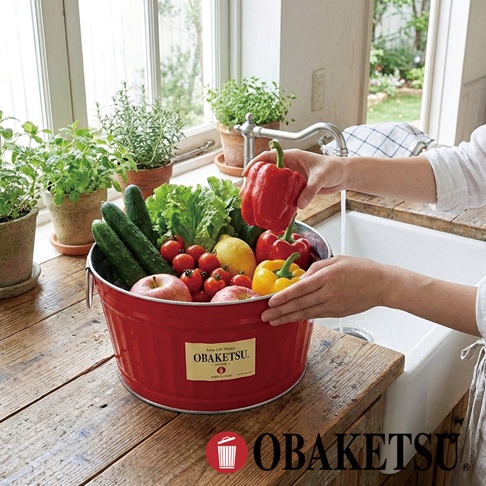 OBAKETSU 手工製紅色迷你桶裝滿新鮮蔬果，放在木製檯面上，旁邊是水槽和窗戶。