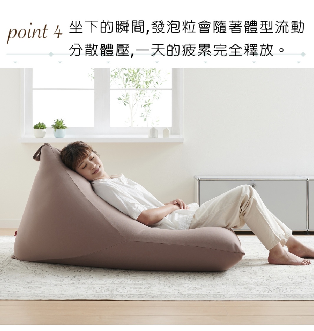 一個女性側躺在一個粉色針織布懶骨頭沙發上，沙發的形狀隨身體而變化，營造出舒適感。