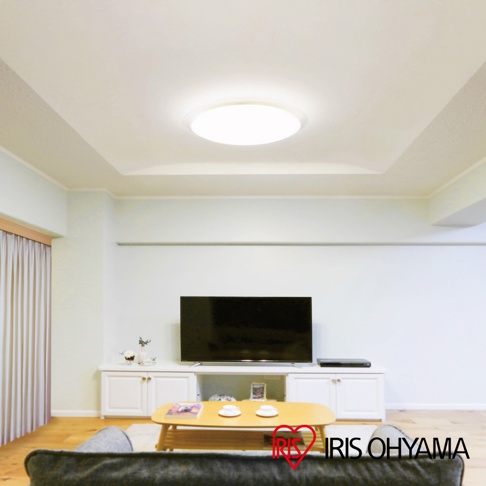 明亮的圓形LED吸頂燈安裝在客廳天花板中央，燈光柔和，燈罩為半透明材質。