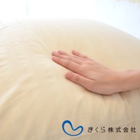 淺米色條紋枕套，布料光滑，一隻手輕柔按壓在枕套上，展示其柔軟觸感。