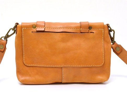 棕色皮革製成的手提包，正面有兩個口袋，帶有金屬扣環的肩帶，縫線細緻。