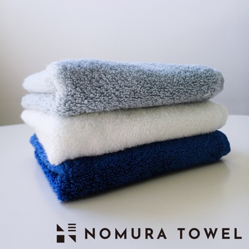 野村毛巾 SUUZO 系列，疊放著藍色、白色、深藍色三條柔軟的毛巾