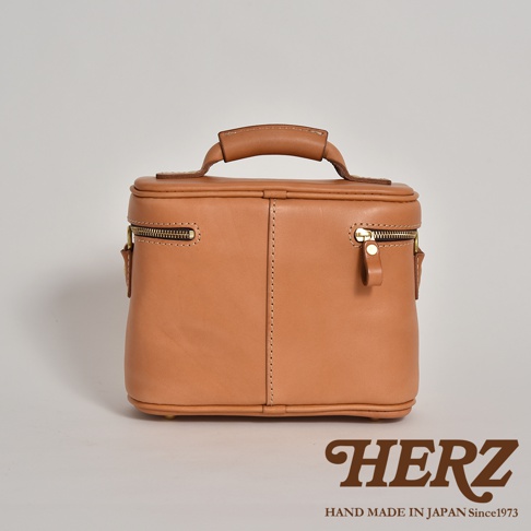 職人手作皮革軟皮相機包 N-6，採用鞣製皮革材質，呈現溫潤的淺棕色調。包身結構方正，設有頂部提把與兩側拉鍊開口，簡潔實用。