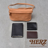 職人手作皮革Organ貼身斜背包M-8，搭配黑色皮夾、咖啡色名片夾以及黑色筆記本，背景為灰色紋理。