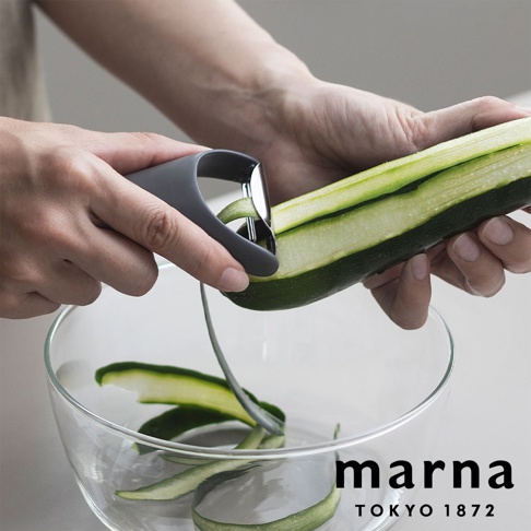 marna TOKYO 1872 品牌標誌下方，雙手正使用灰色削皮器削著一條黃瓜，削下的黃瓜皮呈螺旋狀落入透明玻璃碗中。