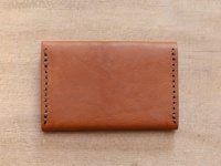 職人手作皮革Organ薄型名片短夾 (GS-49)，呈現溫潤的棕褐色皮革，邊緣有工整的手縫車線，整體造型簡約，適合收納名片。