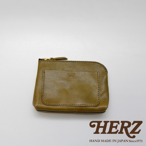 橄欖綠皮革小物收納包，有拉鍊開合與前方口袋，皮革材質，品牌標誌壓印於正面。