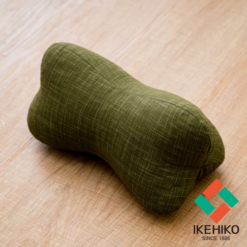綠色骨頭形狀紓壓枕，表面有細緻的格紋織紋，材質為布料，放在木質地板上。