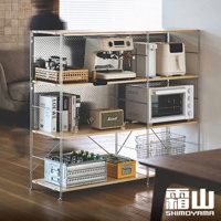 60公分寬不鏽鋼三層收納置物架，淺木色層板搭配銀色金屬支架，上方擺放咖啡機、濾水壺、小烤箱，中間層有音響、書籍，下方層有啤酒箱、置物盒，整體簡約實用。