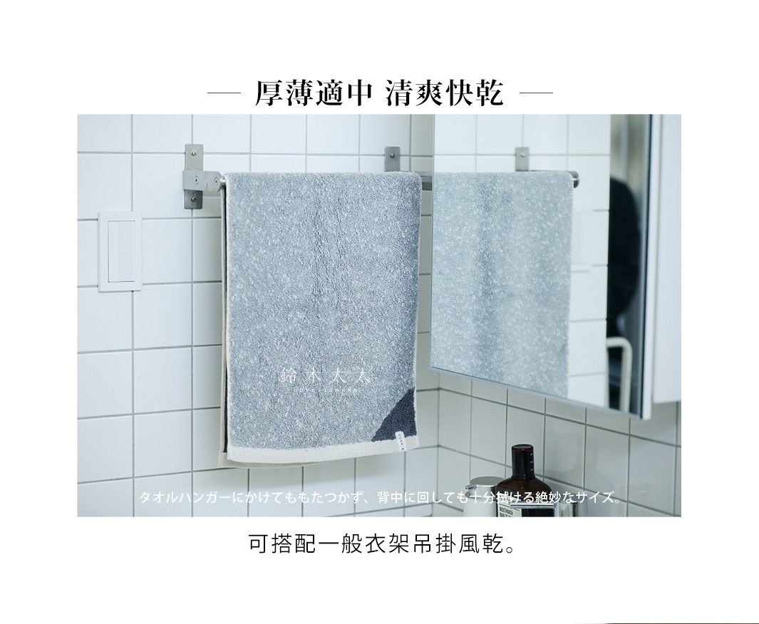 兩條灰色棉麻混紡毛巾，其中一條掛在銀色毛巾架上，另一條映照在鏡子裡。毛巾有雙色設計，邊緣處有深灰色和淺灰色的對比。
