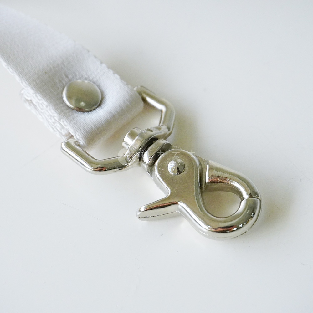 白色織帶連接金屬旋轉掛鉤，織帶上有一顆銀色鉚釘。