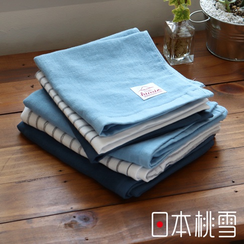 堆疊的紗布方巾，包含淺藍、深藍、白色及條紋款式，材質輕薄，頂部淺藍色方巾上有品牌標籤。