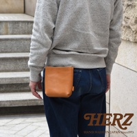 職人手作皮革多用途工作用腰袋 E-27，採用淺棕色光滑皮革製成，方形簡約設計，固定於牛仔褲後腰。