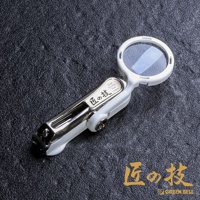 白色不鏽鋼附放大鏡指甲剪，放大鏡部分為圓形，帶有透明鏡片，指甲剪主體為銀色不鏽鋼與白色塑料組合，上面印有日文「匠の技」及英文「High Quality Nail clipper」字樣。