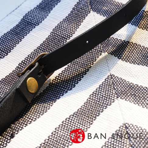 BAN INOUE 品牌字樣的斜背包帶，細節處的金屬釦。