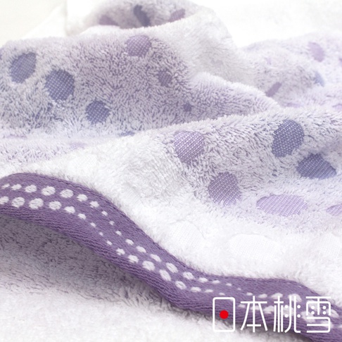 今治水泡泡毛巾，採用柔軟吸水材質，以紫色泡泡圖案點綴白色毛巾，並在邊緣處有紫色滾邊搭配白色圓點裝飾。