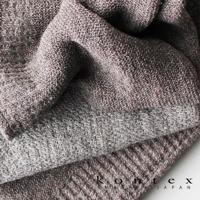 LANA針織風純棉毛巾，採用紋理細緻的針織工藝，呈現細膩的織紋。布料質地柔軟，顏色為帶有紋理的棕灰色調，營造出溫暖自然的質感。