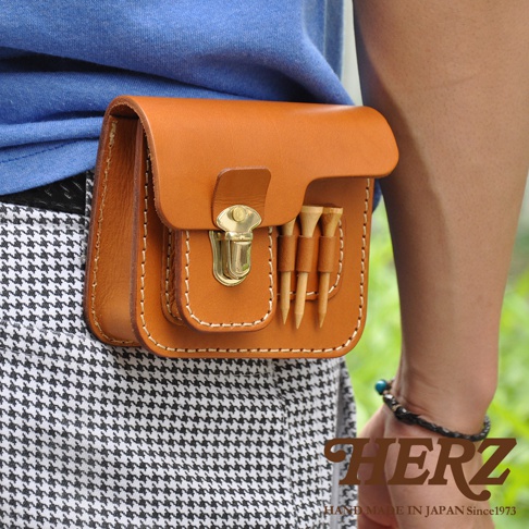 職人手作皮革高爾夫腰包，採用棕褐色皮革製成，設有金屬扣環和三個高爾夫球釘插槽。