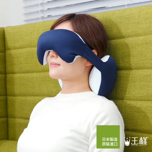 深藍色與白色拼接的眼罩式頸枕，柔軟布料包覆，配戴於一名女子頭部，使其能放鬆休息。