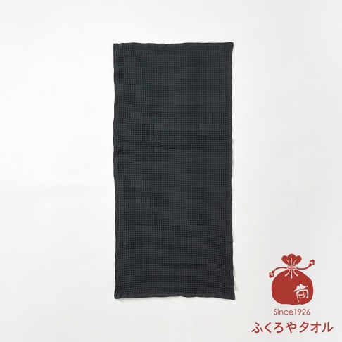 深灰色格紋織法的浴巾，右下角有一個紅色日式束口袋圖案，上面有Since1926字樣及日文ふくろやタオル