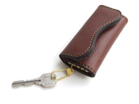 咖啡色皮革鑰匙包，內有六個金屬鑰匙扣，搭配一個銀色鑰匙，手工縫線，簡約設計。