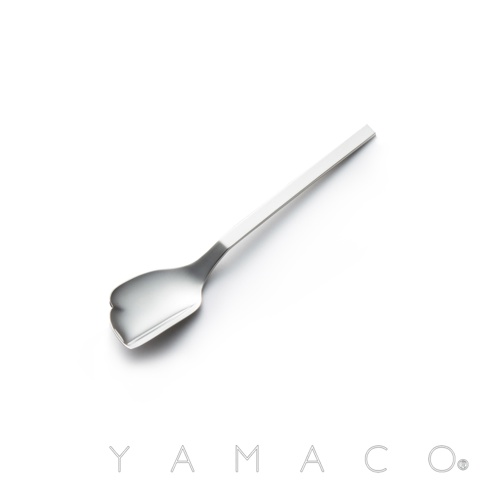 YAMACO 商標與不鏽鋼蛋糕匙，蛋糕匙呈彎月形，手柄呈長方形。