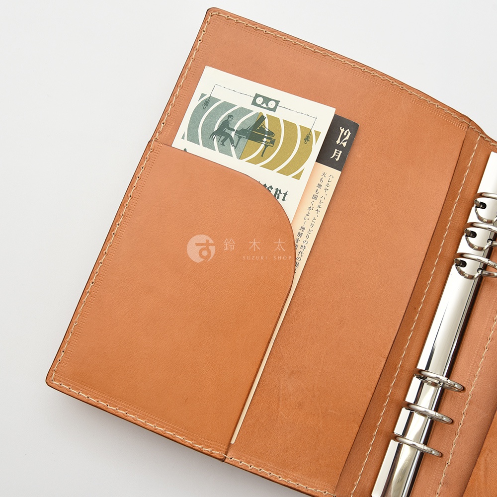 職人手作皮革A5手帳/記事本書套，淺棕色真皮材質，內有卡槽，可放入明信片或小卡。書套右側為銀色六孔活頁夾。