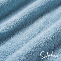 淺藍色柔軟蓬鬆的浴巾特寫，展示其細膩的絨毛紋理。