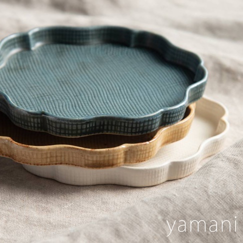 三個疊放的美濃燒花型甜點盤，由上至下分別為藍綠色、淺棕色及白色，盤面帶有細膩的紋理，邊緣呈波浪狀。