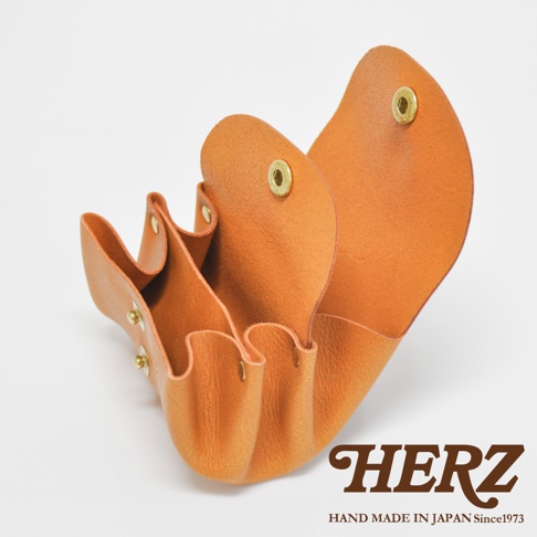 橘色皮革三層收納零錢包，側面展開，內有三個獨立隔層，以金屬壓扣固定。