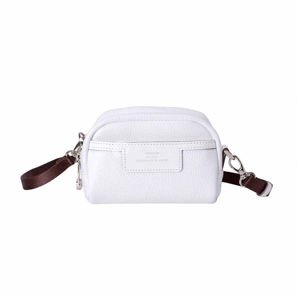 JETTER 迷你側背包 CJTH-040，白色荔枝紋皮革材質，設有深棕色織帶提把及肩帶，搭配銀色金屬扣環。包款正面有一白色皮革標籤，印有品牌資訊。