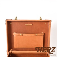 職人手作皮革英倫風便攜手提行李箱 TR-1，展示其內部結構，採用溫暖的棕色皮革材質，配有黃銅色金屬扣件和品牌標誌，內部設有實用的皮革收納袋。