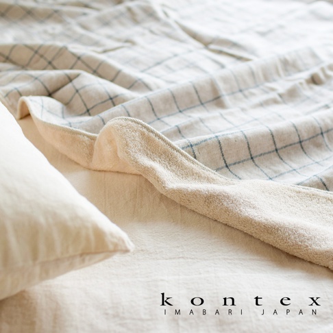 GRAPH 草木染格紋有機棉浴巾，淺米色基底搭配藍色細格紋，觸感蓬鬆柔軟，展現自然質感。