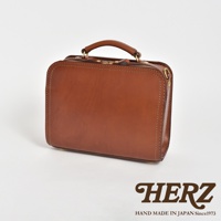 棕色皮革製成的方形單肩包，配有頂部提把、拉鍊開合和縫線細節。