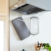 灰色可折疊收納瀝水墊，表面有蜂窩狀紋理，附有白色綁帶，下方懸掛著一個銀色金屬網瀝水籃。