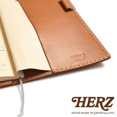 職人手作皮革輕便記事本書套，淺棕色皮革，內含筆記本，書套右側壓印有品牌標誌。