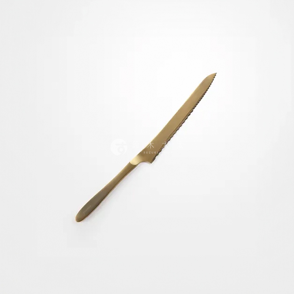 金色金屬麵包刀，刀刃帶有鋸齒，刀柄光滑，頂端有細長刻字。