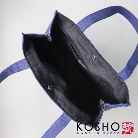 藍紫色棉帆布扇形托特包，內有黑色內襯及口袋，配有兩條同色提把，以銀色按扣閉合。