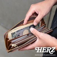 職人手作皮革Organ拉鍊長夾，棕色皮革，拉鍊開闔，內部裝有日圓鈔票與信用卡。