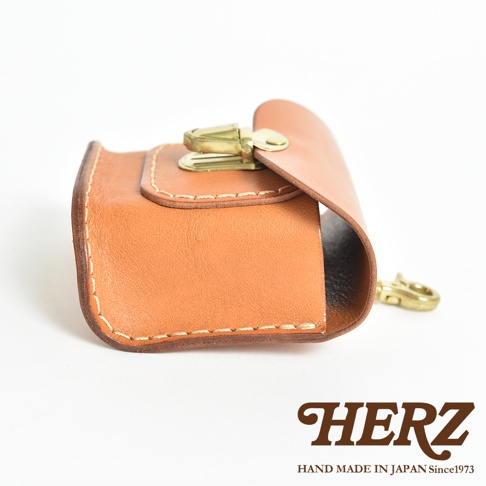 職人手作皮革耳機收納包，淺棕色皮革，配有黃銅色金屬鎖扣及掛鉤，車線明顯，設計簡約。