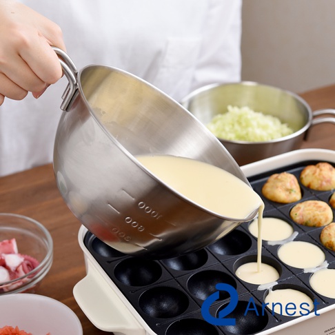 Arnest 不鏽鋼單柄調理碗傾倒takoyaki粉漿至烤盤中，一旁有切塊章魚和高麗菜