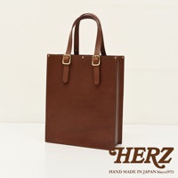 棕色皮革製成的方形托特包，配有兩條皮革提把，提把上裝有金色金屬扣環。